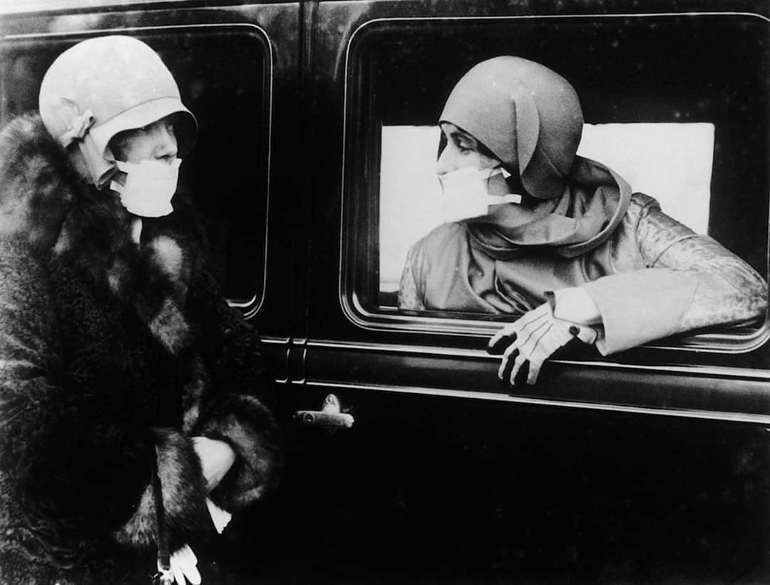 امرأتان ترتديان الكمامة الطبية سنة 1918 لمقاومة وباء الإنفلونزا الإسبانية الرهيب.